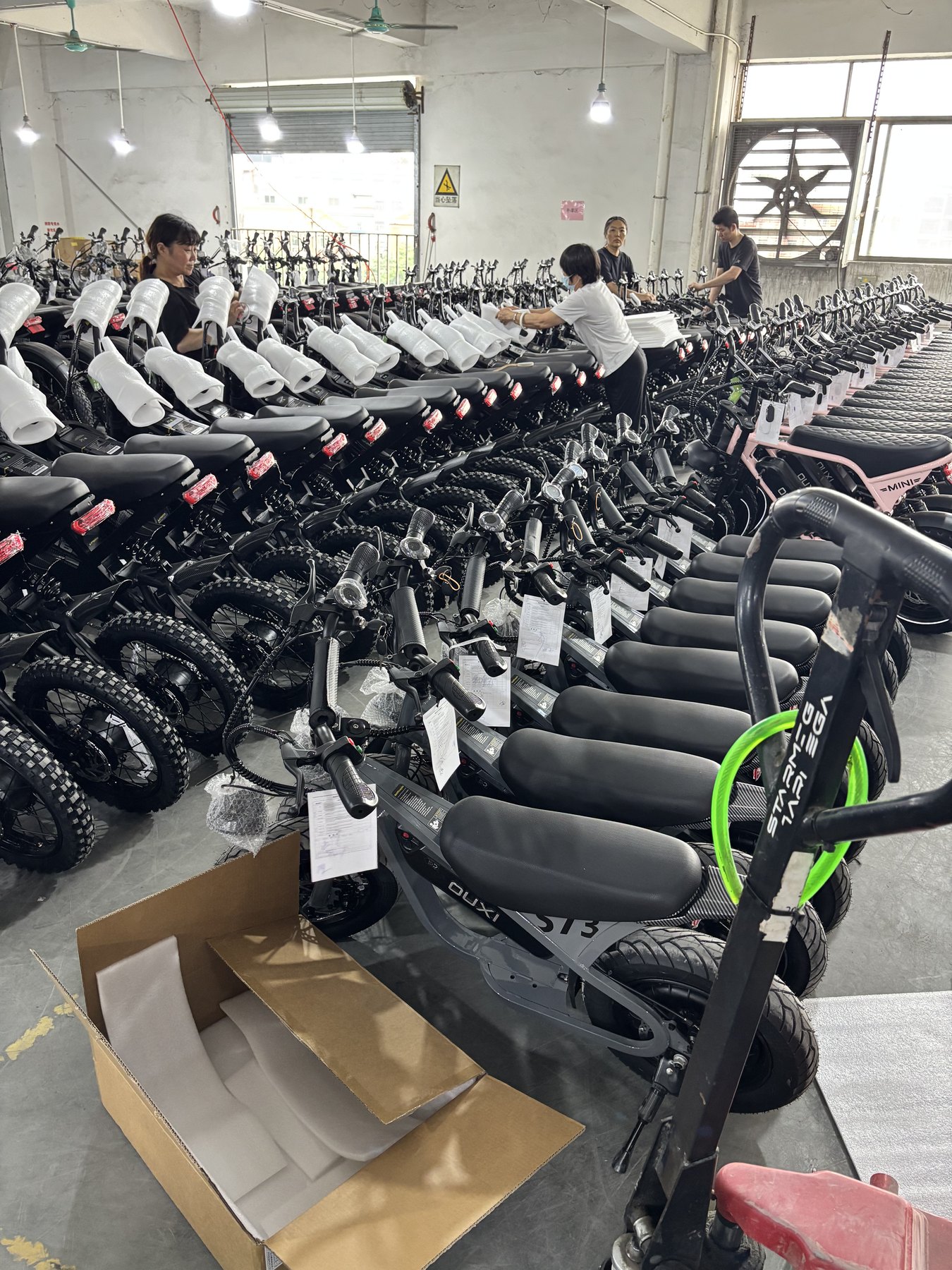 Workers assembling and packing electric bicycles in a China factory