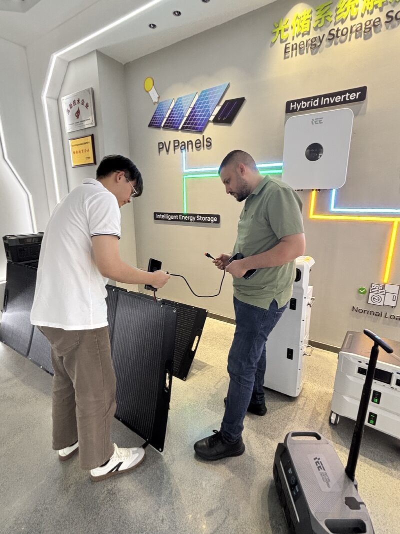 Buyer and supplier reviewing a foldable solar panel connection during an energy storage visit